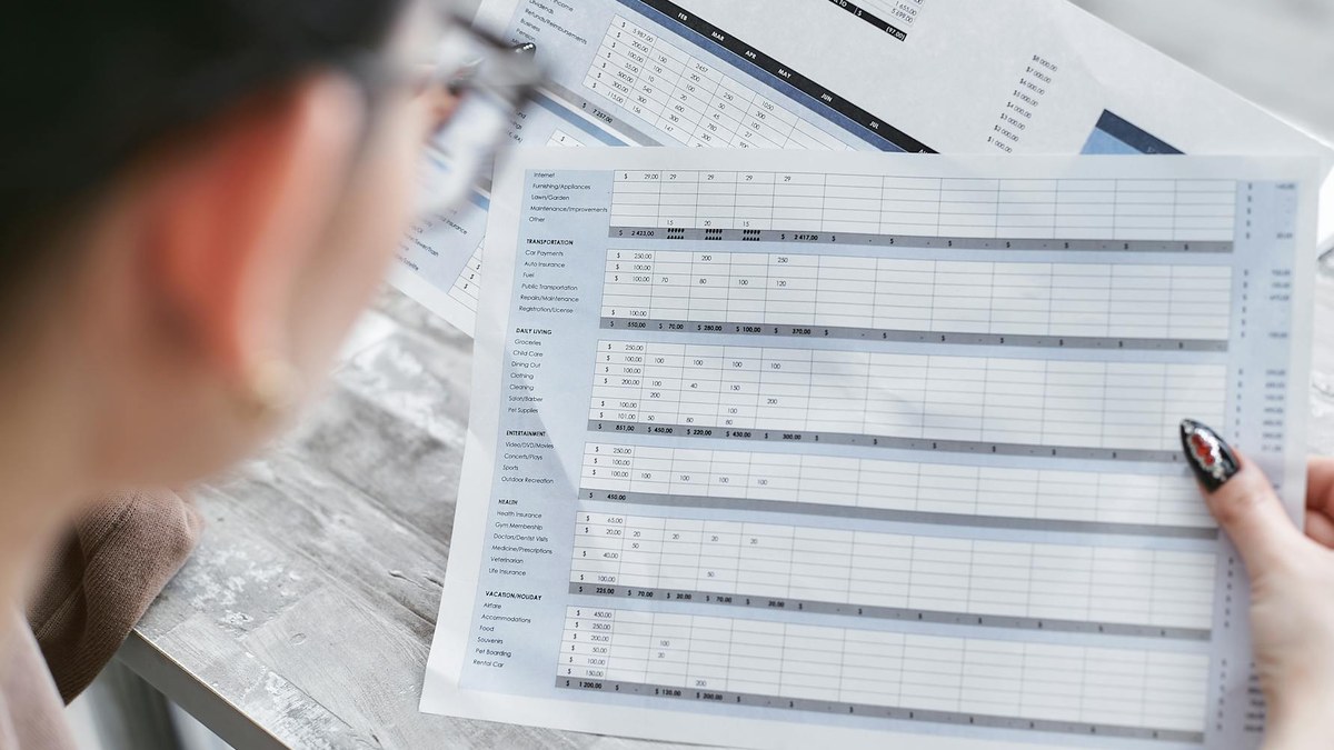 korean young professional reviewing financial documents on a modern desk