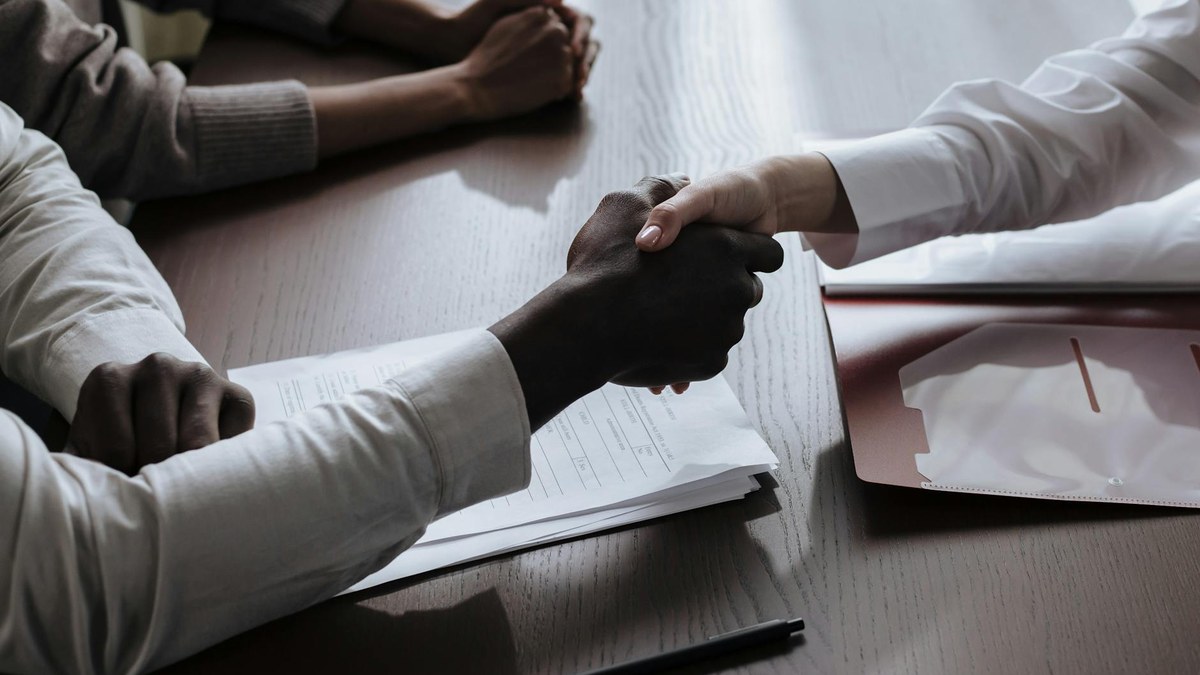 hands shaking over a document, symbolizing a secure contract or agreement