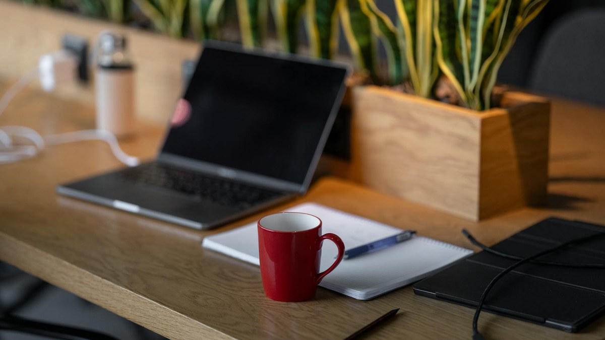 modern minimalist office desk with notebook and coffee, natural light