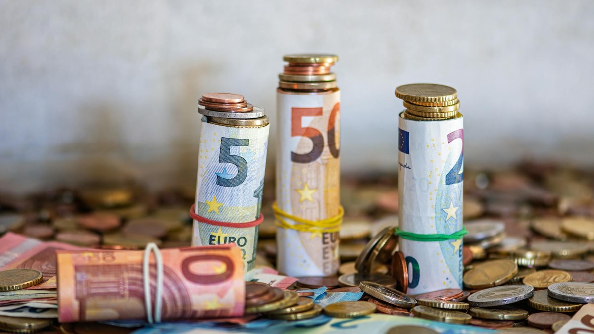 a stack of korean won bills and coins next to a small plant