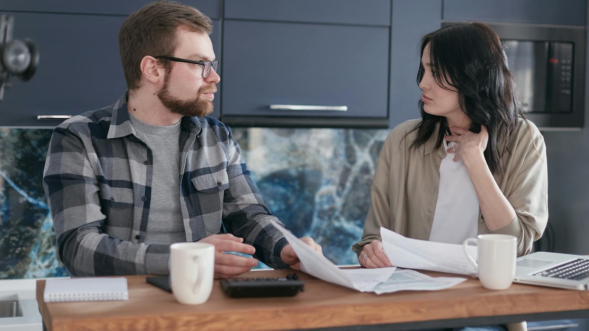 young korean couple planning finances at a modern kitchen table