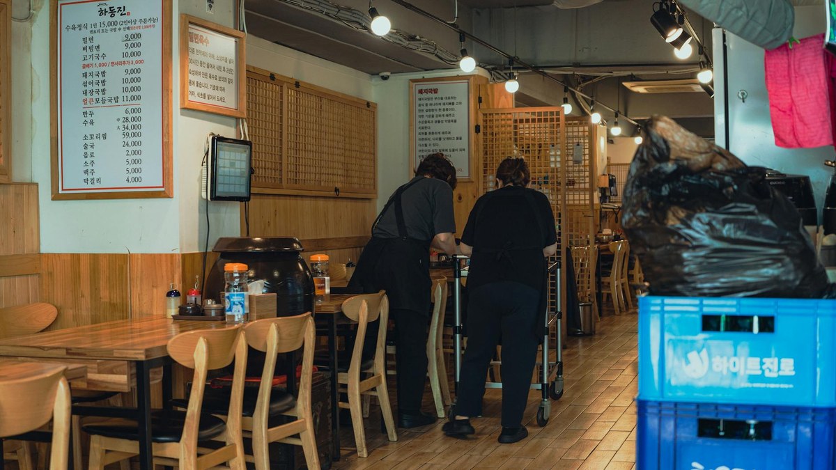 Korean restaurant owner meticulously checking food ingredients in a clean kitchen