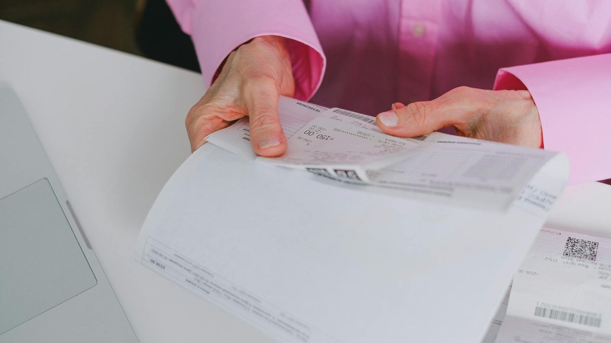 close up of various receipts and invoices on a wooden table