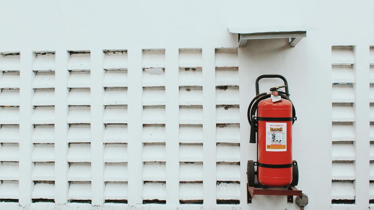 korean small business owner checking fire extinguisher in shop