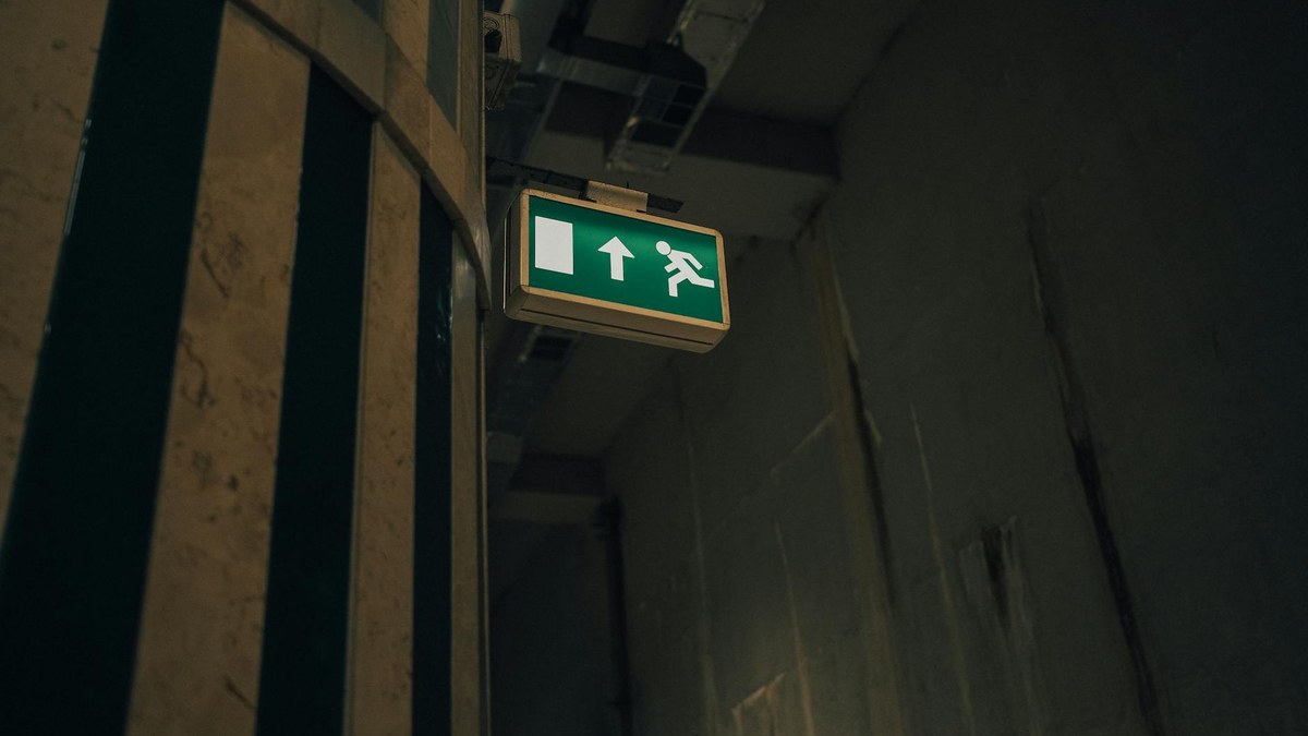 clear emergency exit sign lit up in a hallway