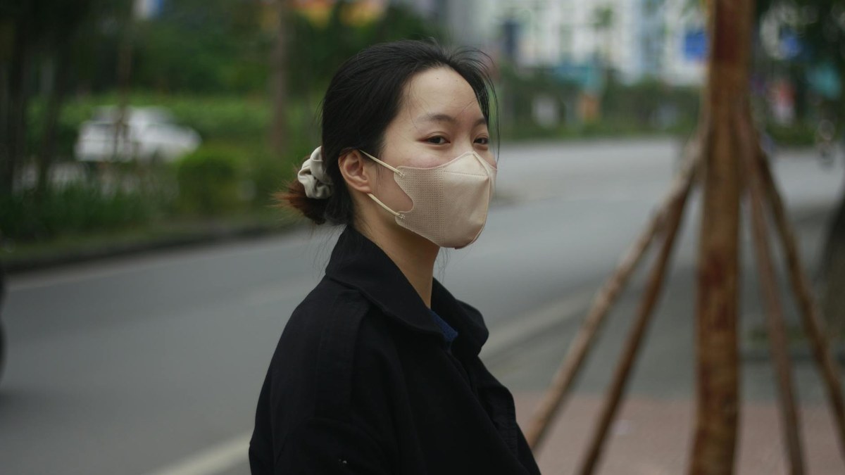 Korean woman wearing a grey KF94 mask with a clean, modern background