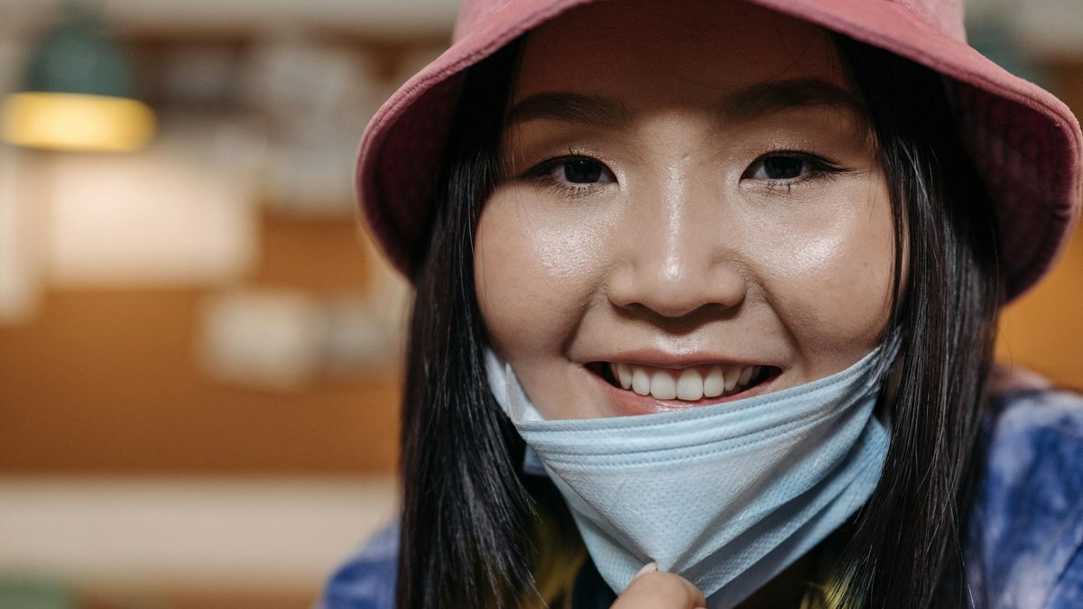 Person smiling comfortably while wearing a grey KF94 mask, highlighting the fit around the face