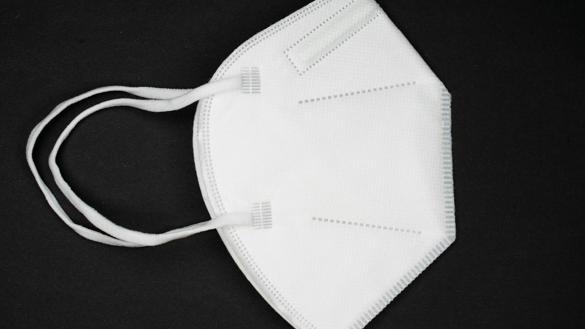 Close-up of a KF94 mask showing its filter layers and ear straps