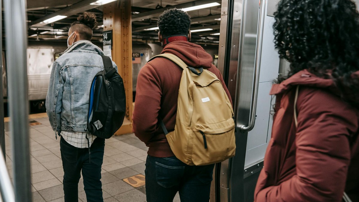 diverse group of people commuting with backpacks in a modern city