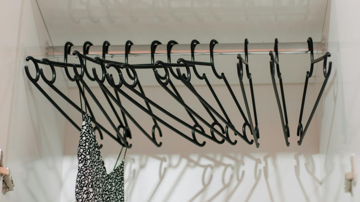 neatly organized closet with various types of clothes on hangers