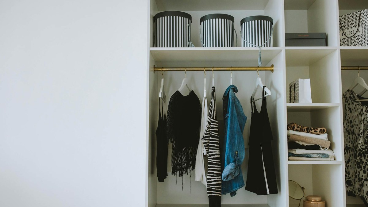 organized bedroom closet with various storage boxes on shelves