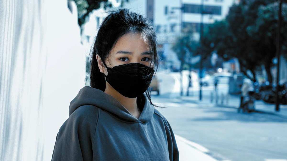 woman wearing kf94 mask walking in city street fine dust