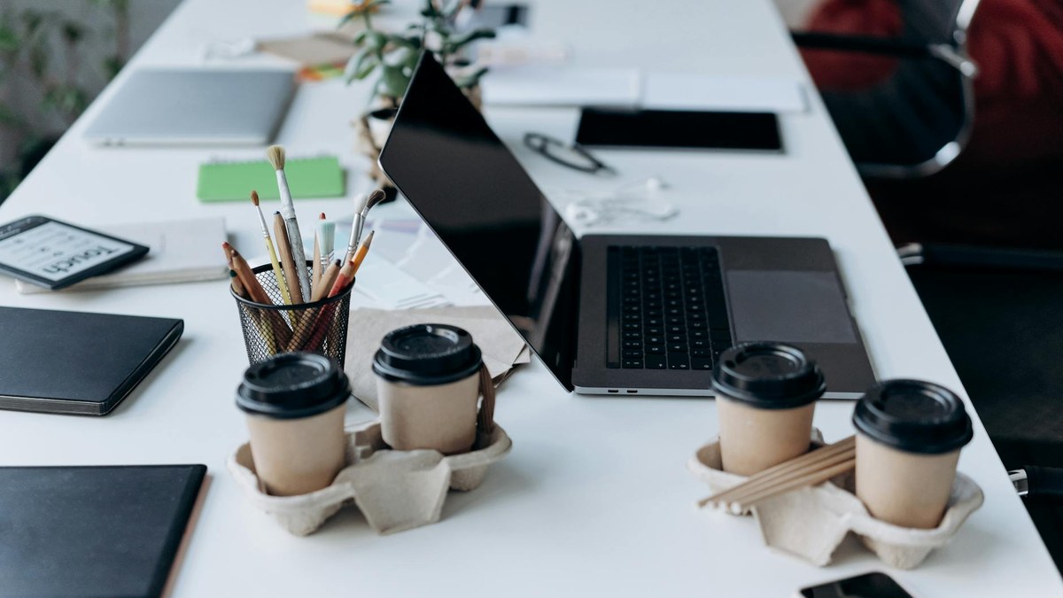 modern minimalist office desk with notebook and coffee, natural light