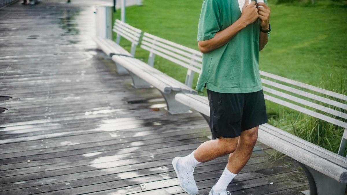 person walking briskly on a park path, wearing athletic clothes