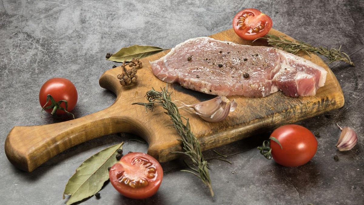 fresh raw smoked duck meat on a wooden board with herbs
