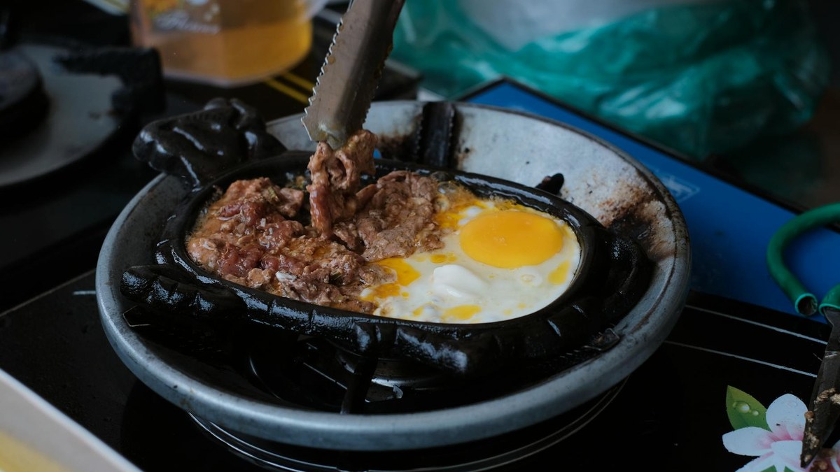 pan-fried smoked duck slices sizzling in a cast iron pan
