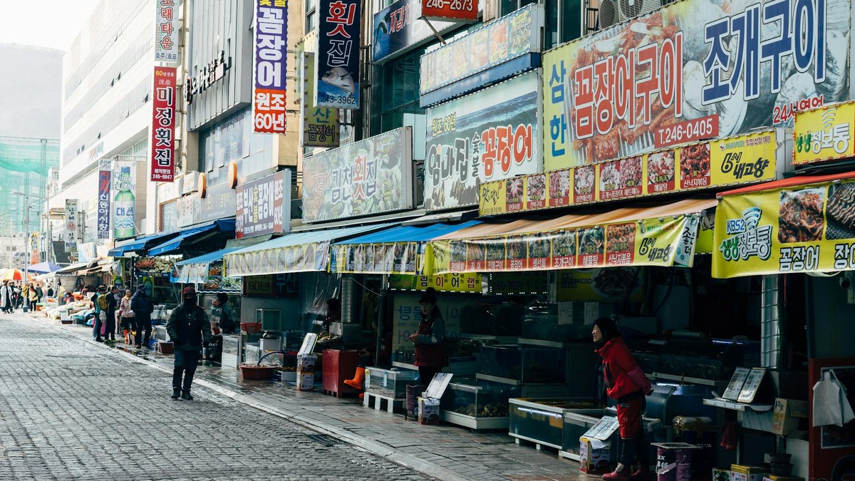traditional Korean market alley, bustling with local vendors and shoppers