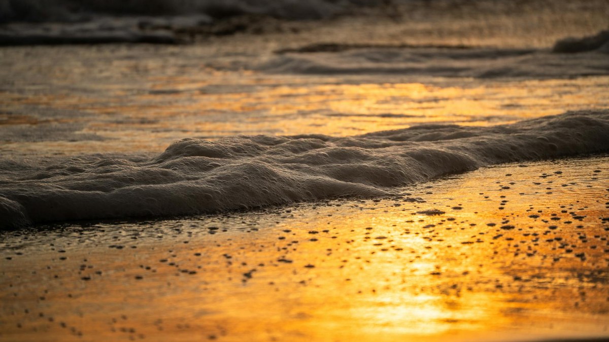 Taean beach sunset with calm waves, golden hour