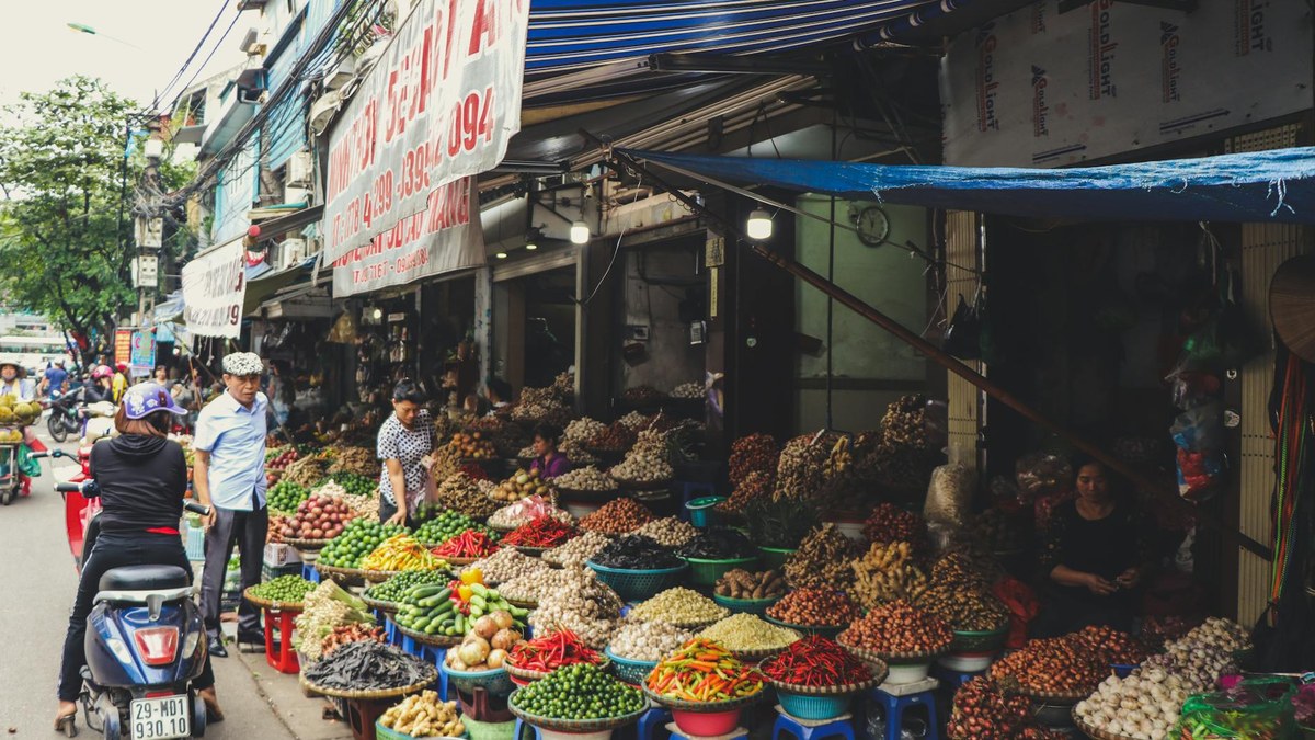 a vibrant street market scene in Da Nang with locals and fresh produce