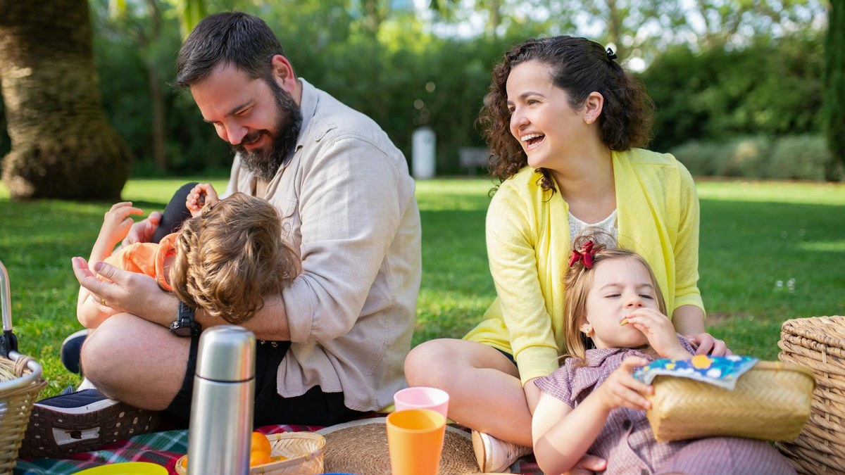 family enjoying picnic in a bustling park on a sunny day