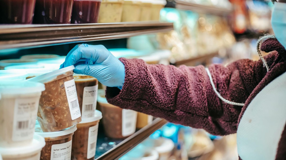 person carefully reading the ingredient list on a food product label