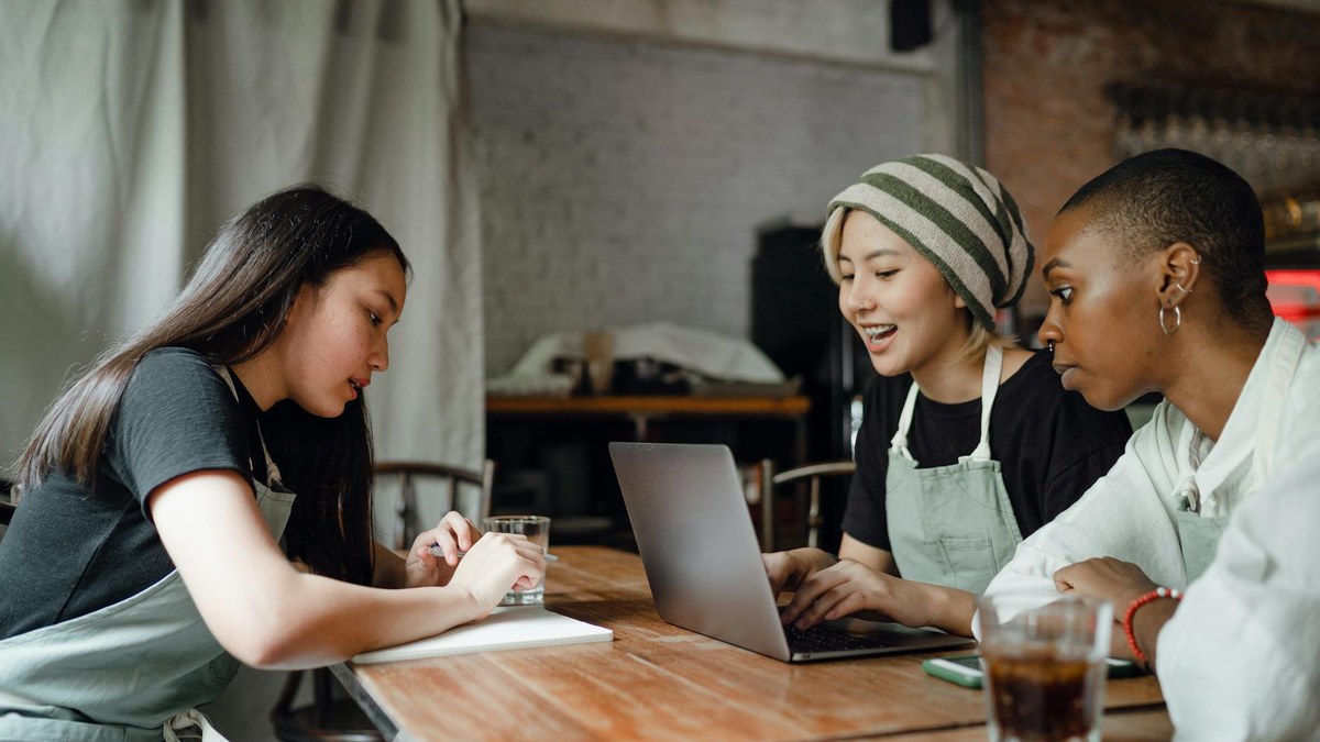 korean small business owner using laptop in a bright cafe