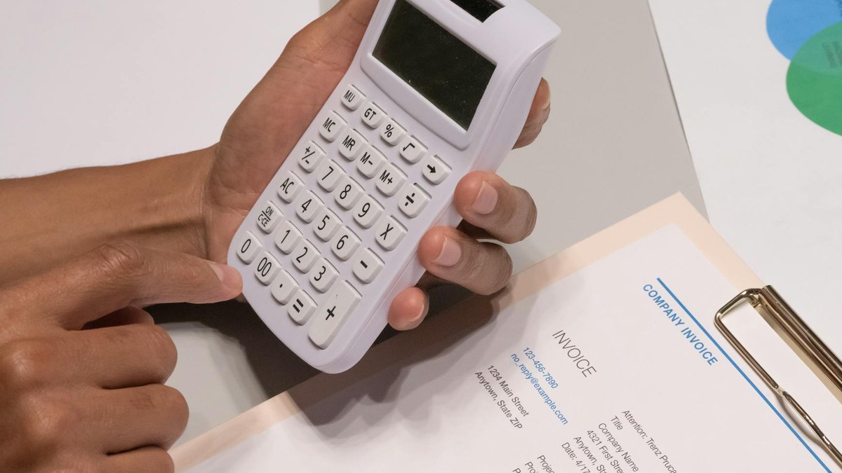 close-up of hands calculating finances with a calculator