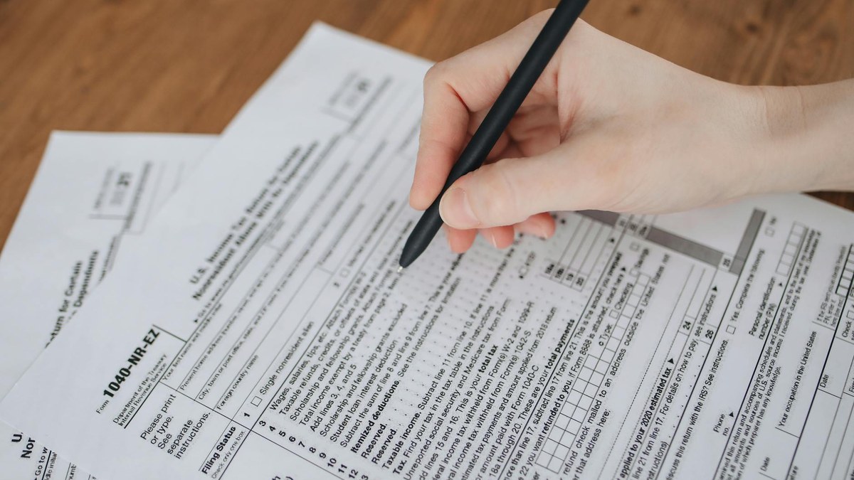 person checking a tax form on a tablet, sunlight through window