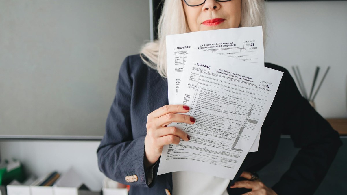 korean small business owner looking stressed at tax documents in office