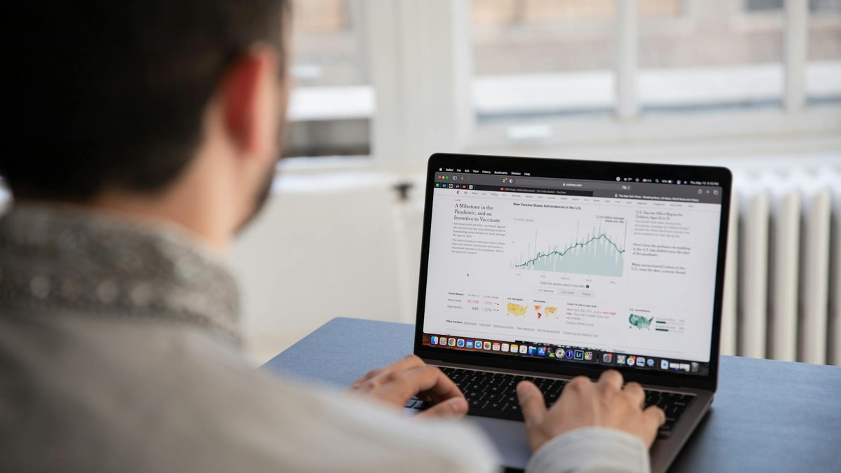 a person typing on a laptop with charts and graphs on screen, focusing on business growth