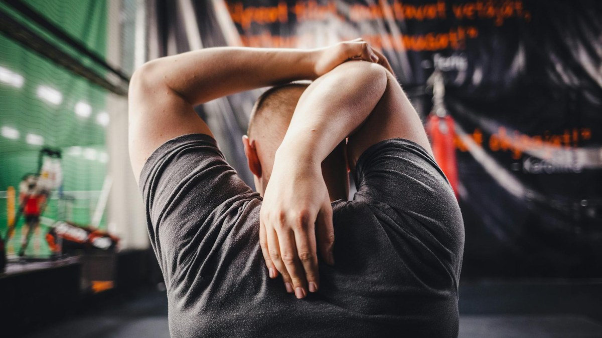 Person performing gentle neck tilt stretch at a desk