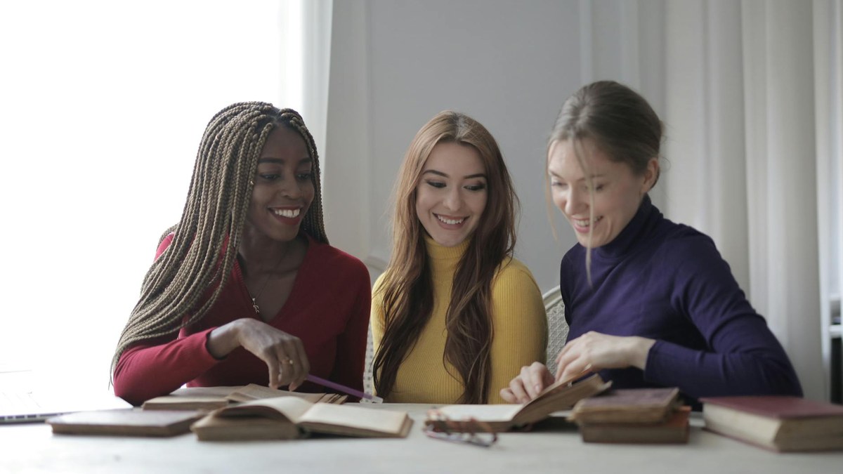 group of people smiling and talking at a book club meeting