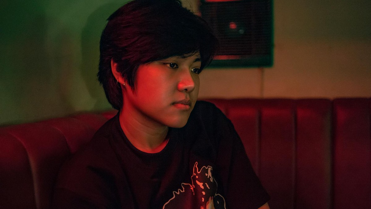 korean woman relaxing on sofa in dimly lit living room after work