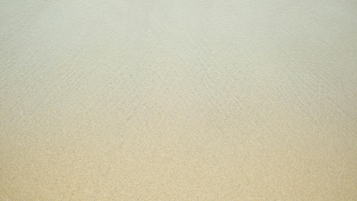 Secluded sandy beach with clear blue water and gentle waves