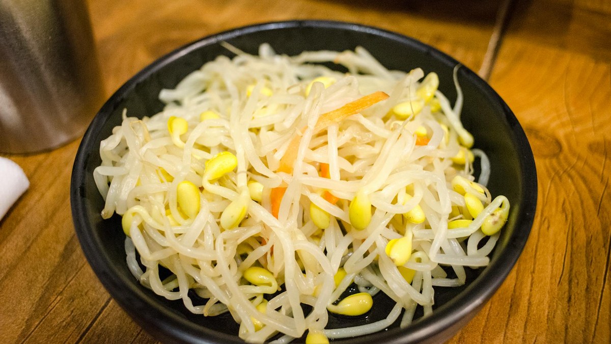 Close-up of a steaming bowl of traditional Korean Kongnamul Gukbap with rice and chopped green onions