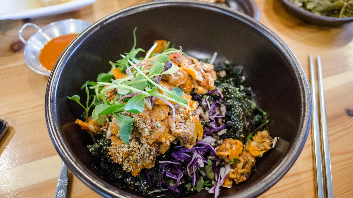 plate of colorful korean bibimbap served in a rustic restaurant