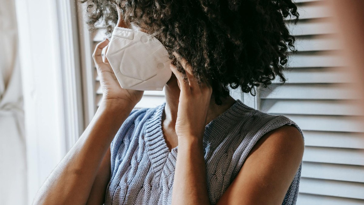 woman wearing a KF94 mask outdoors on a hazy day, looking concerned