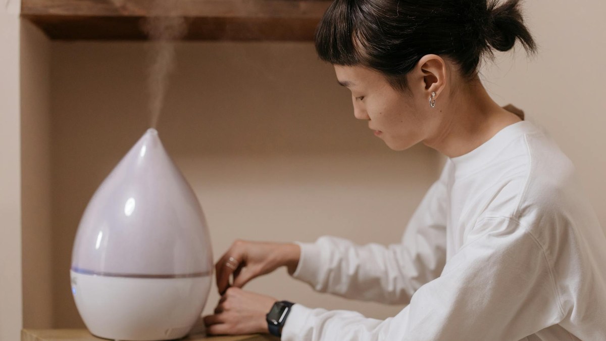 person using a home air purifier in a living room, with clean air indicator lit